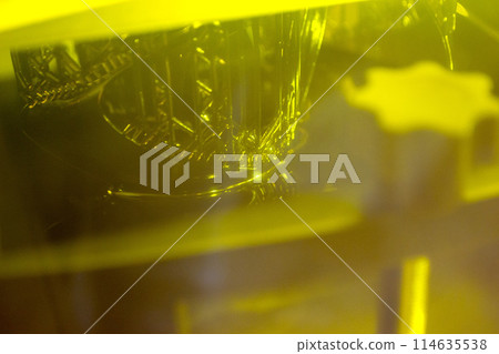 Working of photopolymer sla 3D printer. Platform with building object lowered into liquid photopolymer resins and hardened under ultraviolet laser. Progressive additive technology. 3D printer printing 114635538