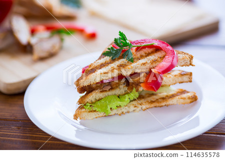 fried toast with chicken, salad, greens on a wooden table fried toast with chicken, salad, greens on a wooden table 114635578
