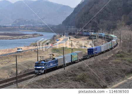 以岡山縣的大河吉井川為背景，在山陽公路上快速行駛的長長的貨運列車。 114636503