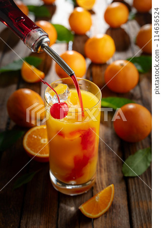 Classic tequila sunrise cocktail on an old wooden table. Classic tequila sunrise cocktail on an old wooden table. 114636524