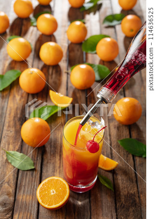 Classic tequila sunrise cocktail on an old wooden table. Classic tequila sunrise cocktail on an old wooden table. 114636525