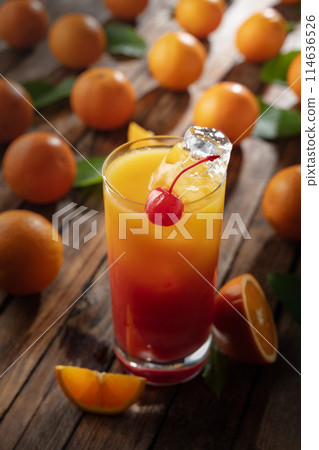 Classic tequila sunrise cocktail on an old wooden table. Classic tequila sunrise cocktail on an old wooden table. 114636526