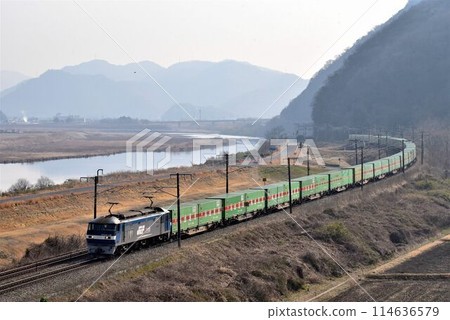 A long freight train that runs fast on Sanyo Road against the backdrop of the Yoshii River, a large river in Okayama Prefecture. 114636579