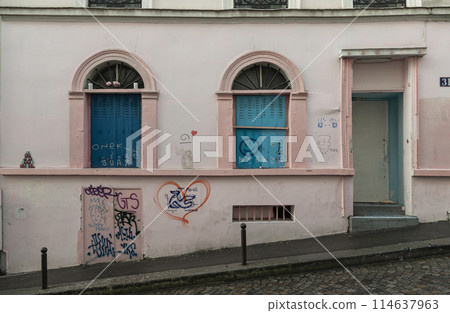View of blue windows and doorway on old wall of a ground floor residence on montmartre streets in Paris. View of blue windows and doorway on old wall of a ground floor residence on montmartre streets in Paris. 114637963