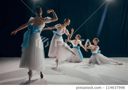 Four young dancers in ethereal white tutus and blue sashes, posing elegantly on dimly lit stage. Choreography 114637996