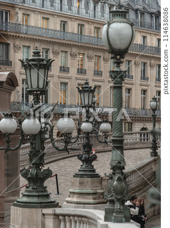 Vintage lamp posts on with white handrail with the historic building in background at The opera house Palais Garnier. 114638086