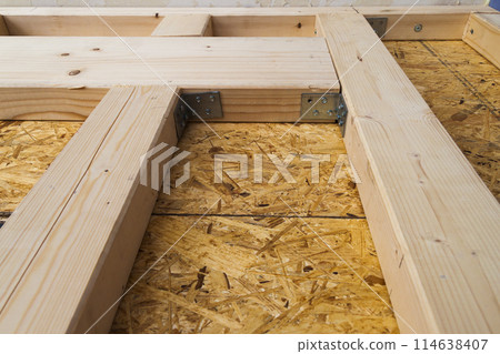 Construction of wood frame walls of a new country house site. Unfinished construction work inside. 114638407