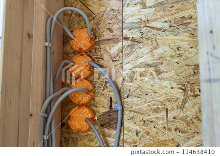 New electrical installation, socket plastic boxes and electrical cables on the wall, renovation concept. Electrical wiring installation. New electrical installation, socket plastic boxes and electrical cables on the wall, renovation concept. Electrical wiring installation. 114638410