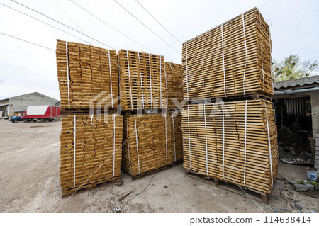 Stack of new wooden boards and studs at the lumber yard. Wooden plates on piles for furniture materials Stack of new wooden boards and studs at the lumber yard. Wooden plates on piles for furniture materials 114638414