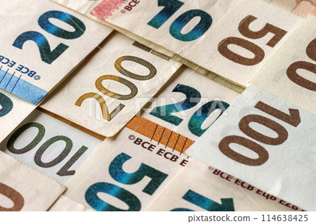 Money and finances concept. Bright colorful abstract surface, background of euro national currency different bills. Banknotes worth ten, twenty, fifty, hundred and two hundred euro. 114638425