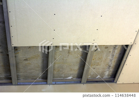 Suspended ceiling from drywall fixed to metal frame with screws. Suspended ceiling from drywall fixed to metal frame with screws. 114638448