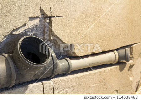 Installation of sewer pipes in a bathroom of an apartment interior during renovation works. Gray plastic drain pipe for used water. 114638468