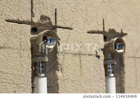 Water pipes made of polypropylene in the wall, plumbing in the house. Installation of sewer pipes in a bathroom of an apartment interior during renovation works. Gray plastic drain pipe for used water Water pipes made of polypropylene in the wall, plumbing in the house. Installation of sewer pipes in a bathroom of an apartment interior during renovation works. Gray plastic drain pipe for used water 114638469