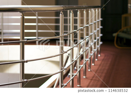 Shiny chrome metal fencing and railings in a hotel interior 114638532