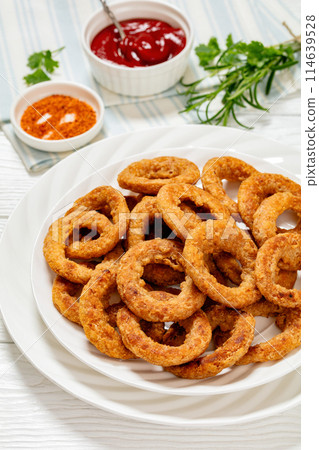 deep fried crispy onion rings on white plate 114639528