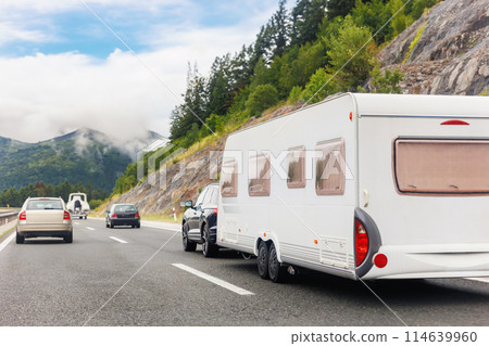 Scenic view big modern white family rv camper van vehicle drive Europe highway road alpine mountain cloud in summer day. Rving motorhome lifestyle travel and adventure tourism trip journey concept 114639960