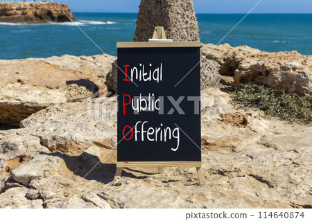 IPO initial public offering symbol. Concept words IPO initial public offering on beautiful yellow blackboard. Beautiful stone sea background. Business IPO initial public offering concept. Copy space. 114640874