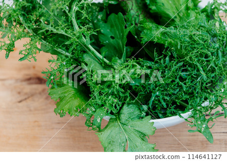 Green fresh mix lettuce salad leaves in white bowl. Green fresh mix lettuce salad leaves in white bowl. 114641127