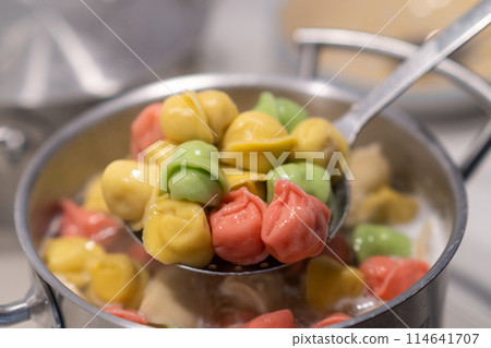 In a pot, colorful dumplings are being boiled. Preparing lunch or dinner for children and family. In a pot, colorful dumplings are being boiled. Preparing lunch or dinner for children and family. 114641707