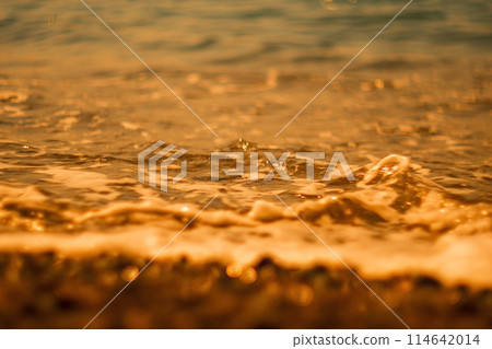 Abstract nature summer ocean sunset sea background. Small waves on water surface in motion blur with bokeh lights from sunrise. Holiday, vacation and recreational background concept 114642014