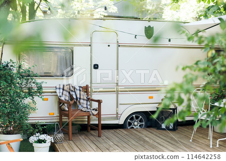 Van mobile home with terrace, House on wheels. Caravan camping. trailer-house on wheels in a green forest garden. trailer Van mobile home with terrace, House on wheels. Caravan camping. trailer-house on wheels in a green forest garden. trailer 114642258