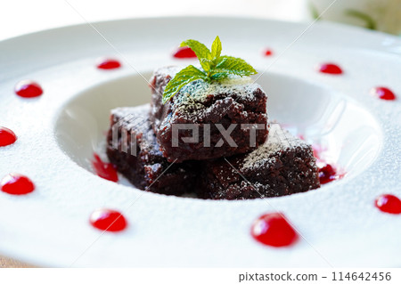 Close-up of chocolate brownie with raspberry sauce 114642456