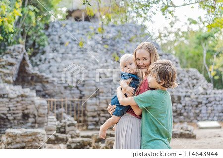 Mom and two sons tourists at Coba, Mexico. Ancient mayan city in Mexico. Coba is an archaeological area and a famous landmark of Yucatan Peninsula. Cloudy sky over a pyramid in Mexico 114643944