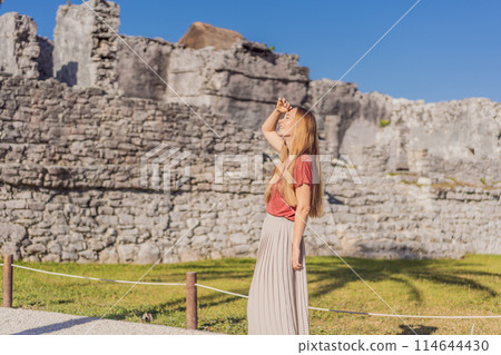 Woman tourist enjoying the view Pre-Columbian Mayan walled city of Tulum, Quintana Roo, Mexico, North America, Tulum, Mexico. El Castillo - castle the Mayan city of Tulum main temple 114644430