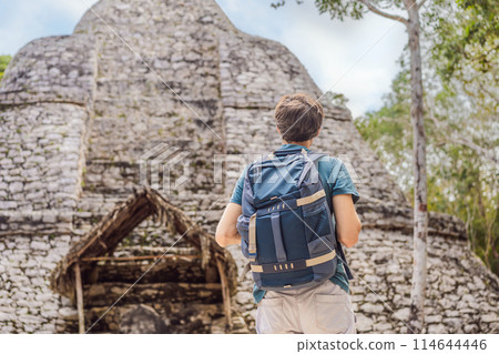 Man tourist at Coba, Mexico. Ancient mayan city in Mexico. Coba is an archaeological area and a famous landmark of Yucatan Peninsula. Cloudy sky over a pyramid in Mexico Man tourist at Coba, Mexico. Ancient mayan city in Mexico. Coba is an archaeological area and a famous landmark of Yucatan Peninsula. Cloudy sky over a pyramid in Mexico 114644446