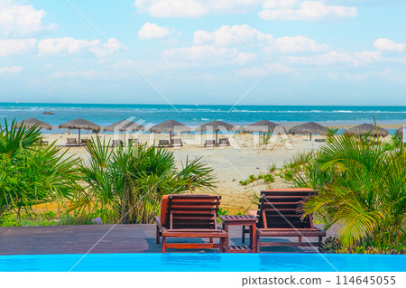 Beautiful minimalist pool side and ocean view with clear blue sky. 114645055