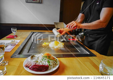 chef's hands with spatula over teppanyaki. Teppan show 114645171