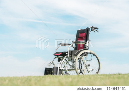 A wheelchair outdoors in a park under a blue sky A wheelchair outdoors in a park under a blue sky 114645461