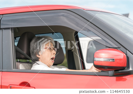 Asian senior woman who is about to have a traffic accident or rear-end collision while driving a car and brakes suddenly 114645530