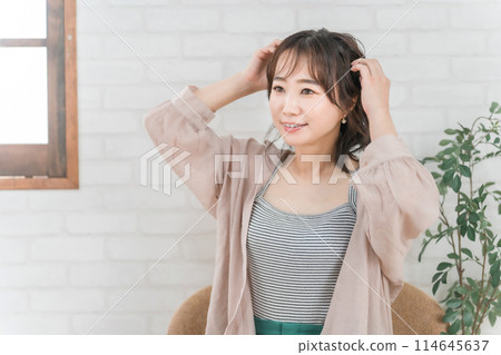 Profile of a stylish woman setting her hair in a room Profile of a stylish woman setting her hair in a room 114645637