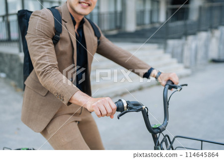 Young businessman in suit in city bike to work eco friendly alternative vehicle green energy 114645864