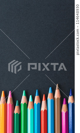 Colored pencils on black paper stock photo 114648930