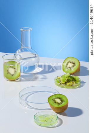 High angle shot photography at the scene lab items and fresh kiwi ingredient flat lay on white table top against blue background. Blank space for designing and adding text High angle shot photography at the scene lab items and fresh kiwi ingredient flat lay on white table top against blue background. Blank space for designing and adding text 114649654