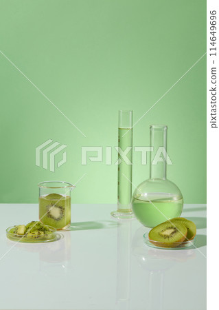 Vacant space in the middle surrounded by some types of laboratory glassware of green liquid and kiwi slices. Kiwis help balance your sebaceous gland production 114649696