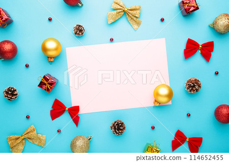 Christmas composition with gold and red decoration on blue background with copy space Christmas composition with gold and red decoration on blue background with copy space 114652455