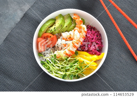 Fresh seafood recipe. Shrimps poke bowl with rice, red cabbage, avocado, yellow sweet pepper. Food concept poke bowl on gray background Fresh seafood recipe. Shrimps poke bowl with rice, red cabbage, avocado, yellow sweet pepper. Food concept poke bowl on gray background 114653529