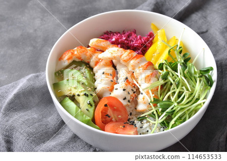 Fresh seafood recipe. Shrimps poke bowl with rice, red cabbage, avocado, yellow sweet pepper. Food concept poke bowl on gray background 114653533