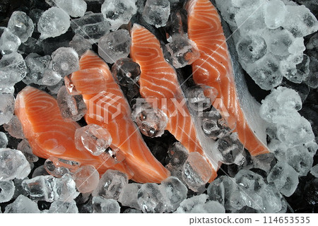 Fresh salmon steaks . Fresh salmon steaks on ice and black background 114653535