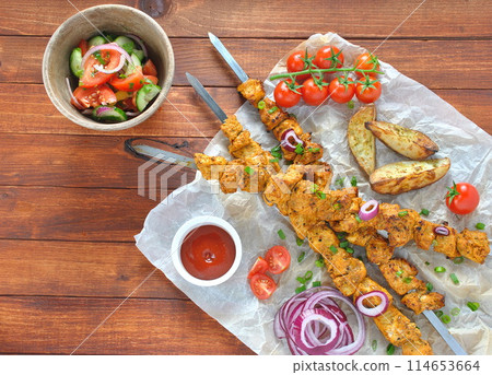 Barbecue meat. Chicken kebab. Chicken Shashlik with vegetables on wooden background. Rustic style. Top view 114653664