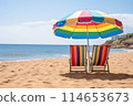 Tropical sandy beach with colorful parasol, sunbeds, and sand toys for a perfect vacation 114653673
