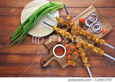Barbecue meat. Chicken kebab. Chicken Shashlik with vegetables on wooden background. Rustic style. Top view 114653707