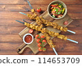 Barbecue meat. Chicken kebab. Chicken Shashlik with vegetables on wooden background. Rustic style. Top view 114653709