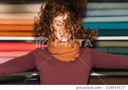 Stylish woman with curly hair in craft textile store, design concept 114654577