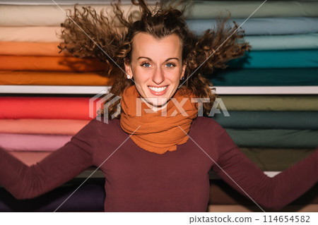 Stylish woman with curly hair in craft textile store, design concept 114654582