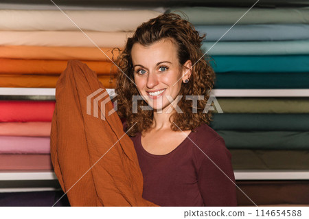 Stylish woman with curly hair in craft textile store, design concept 114654588