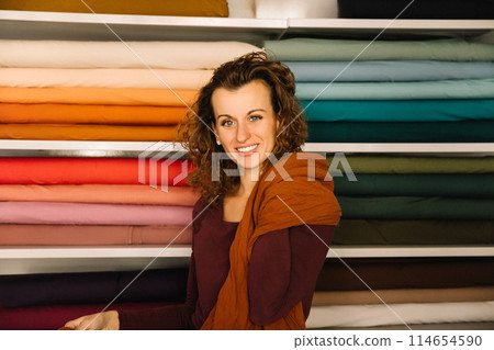Stylish woman with curly hair in craft textile store, design concept 114654590